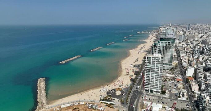 Aerial footage Tel Aviv beach promenade with the line of hotels in the background. Filmed in C4K Apple ProRes 422 HQ