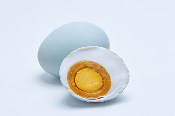 Salted duck eggs ( Telur Asin ) with one egg cut in half to expose the inside, popular food in Indonesia as well as Asia, Isolated white background