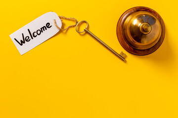 Golden hotel service bell with key on reception desk