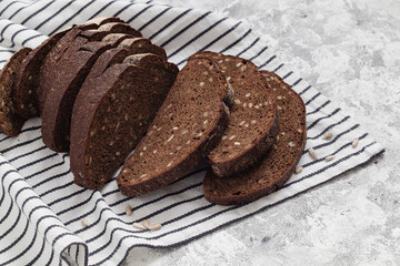 Fresh brown sliced rye bread on the striped textile. Wholegrain gluten free bread. Copy space.