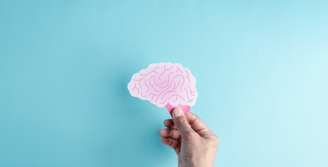 Hand holding human brain paper cut, idea creative intelligence thinking or Awareness of Alzheimer, Parkinson's disease, dementia, stroke, seizure or mental health. Neurology and Psychology care.