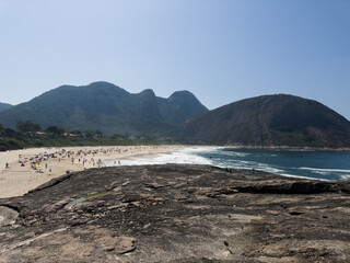 View of Itacoatiara beach in Niter&oacute;i in Rio de Janeiro, Brazil with its beautiful hills surrounding the beach, big waves in a sunny summer day
