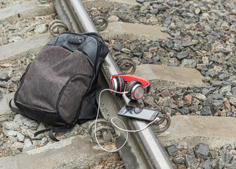 Railway crossing. on it lies a backpack, shoes, headphones. The concept of increased attention to paths.