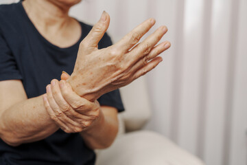 Close up hands of asian senior elderly woman with parkinson's disease symptom, hand numbness,...