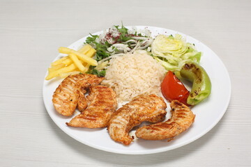 Grilled chicken served with rice, fries and green salad