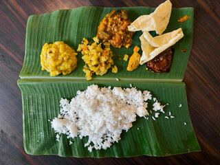 South Indian cuisine banana leaf rice serve with various curry and vegetable.