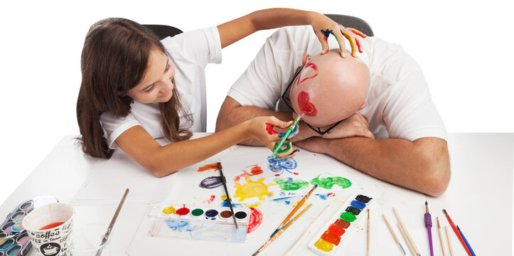 Painting concept. Schoolgirl painting with father during therapy at home with his tutor with learning and having fun together.
