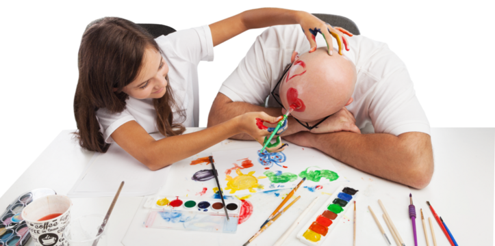 Painting concept. Schoolgirl painting with father during therapy at home with his tutor with learning and having fun together.