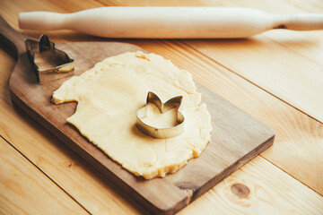 rolled out dough on a wooden table with a cookie cutter in the shape of a rabbit. the process of...
