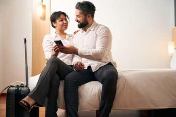 Elegant woman and her companion sitting in hotel room