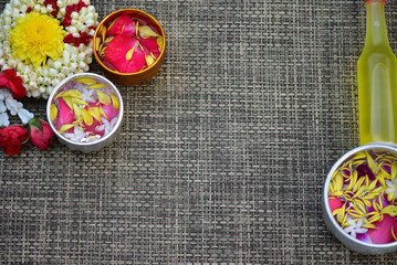 Fototapeta na wymiar Jasmine water and rose petals in a bowl for Songkran festival in Thailand. with space for text.