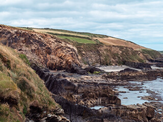 Picturesque landscape. Wild vegetation on stony soil. Cloudy sky. Views on the wild Atlantic way, hills, clouds.