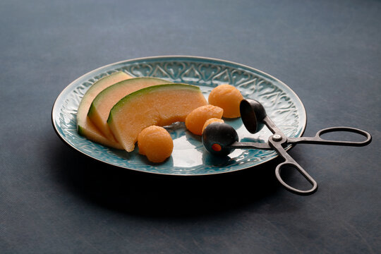 Cantaloupe on a Blue Plate with Vintage Fuit Baller
