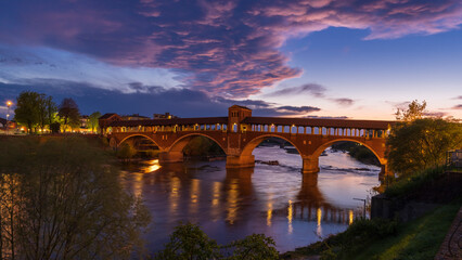 Fototapeta na wymiar Ponte Coperto (covered bridge) over Ticino river in Pavia at blue hour, Lombardy, italy.