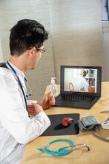 Doctor in remote consultation with 30 year old patient with back pain.