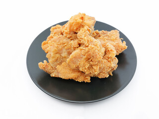 Heap of crispy fried chicken in a black plate isolated on white background. Selective focus.