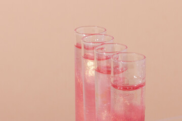 test tube with liquid rose gold. Glitter, varnish, liquid. Sequins. Laboratory research of cosmetics and liquids. The current rose gold.