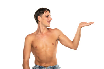 Muscular man with his arm outstretched. topless young fashion model with his hand in the air holding imaginary object . Isolated on a white studio background