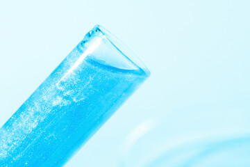 Glass flasks with liquid blue liquid. Glitter, varnish, liquid. Sequins. Laboratory research of cosmetics and liquids. Current naked gel.