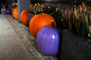Pumpkins decor at outdoors cafe in city street, festive holiday decor storefronts and buildings. Halloween festive decoration outdoor. Happy halloween. Autumn market in town. Copy space. High quality