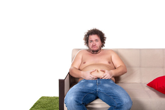 Funny fat man is sitting on the couch. Diet and healthy lifestyle.