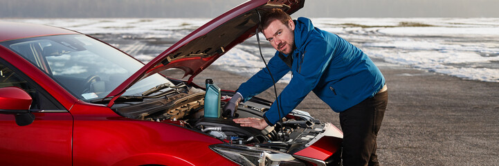 A man checking the oil level in a modern car.