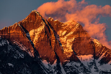 Pink sunset on top of Lhotse with marshmallow cloud over its peak