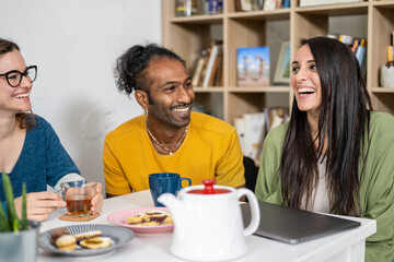 Happy young friends having a break in coffee shop, multiracial universitary student having fun during breakfast