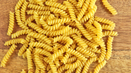 pâtes fusilli crues en gros plan, sur une table	