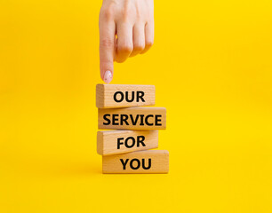 Our service for you symbol. Wooden blocks with words Our service for you. Beautiful yellow background. Businessman hand. Business and Our service for you concept. Copy space.