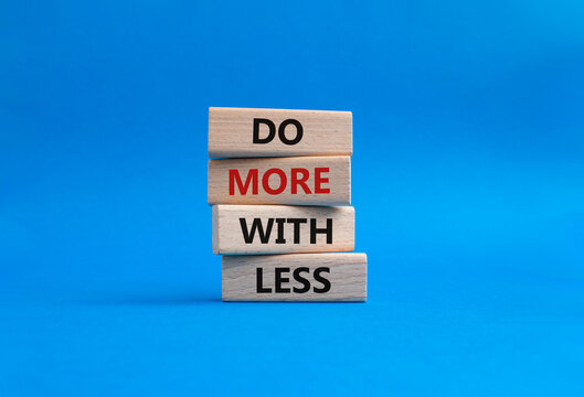 Do more with less symbol. Concept words Do more with less on wooden blocks. Beautiful blue background. Business and Do more with less concept. Copy space.