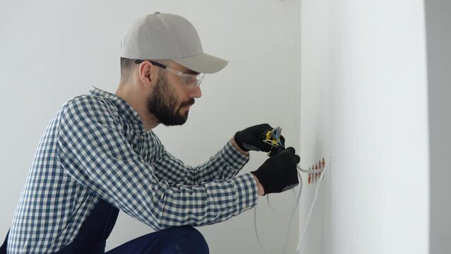 Electrician installs decorative frame on electric and TV sockets