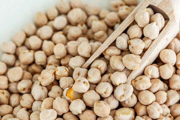 Dry chickpeas with a wooden scoop. Health and natural products. Close-up.