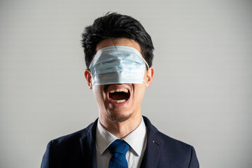 Screaming man wearing a mask over his eyes.