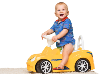 Cute little boy on toy car looking at camera
