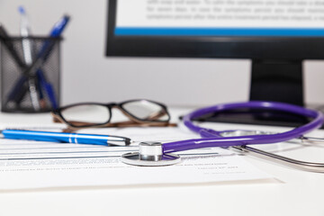 A doctor's table with stethoscope on focus