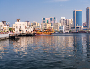 View along the Creek towards Deira with large dhow tour boats docked by the Al Seef boardwalk in Dubai, UAE