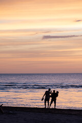 silhouette of a family on the beach enjoying sunset