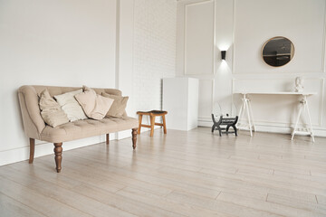 A beige sofa with pillows near the wall next to a small table. Part of the interior with copy space.High quality photo