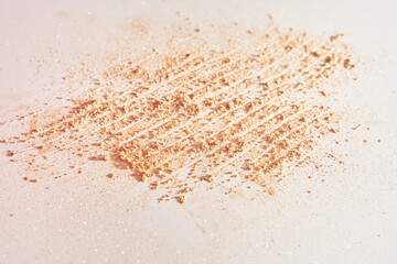 Fototapeta na wymiar A smear of face powder, on a white background. Minimalistic modern cosmetic scene of bronzer or shadows, top view with space to copy. High quality photo
