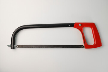 tools. on a light background, a hacksaw with a red handle. for advertising banners of construction label stores and more