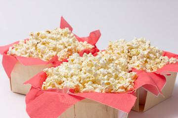 Popcorn presented on red paper napkins inside wooden bowls.