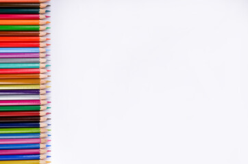 Composition with color pencils on white background, flat lay. Space for text