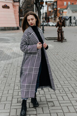 Fototapeta na wymiar a girl in a coat walks around the city