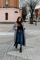 Fototapeta premium a girl in a coat walks around the city