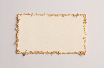 Gold (bronze) glitter empty canvas frame on beige gray paper background. Abstract copy space texture.