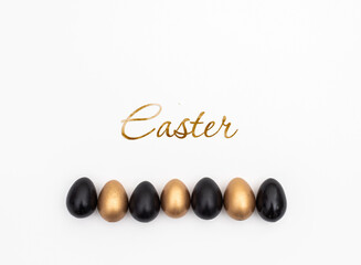 Flat Lay of Golden and Black Easter Eggs on white background. Easter background or easter concept. Still life