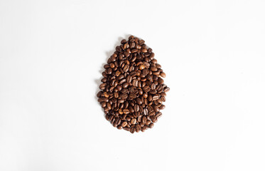 Creative composition of easter egg shape made of coffee roasted beanson white background. Realistic aesthetic look. Easter concept