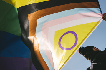 girl with back holding lgtb rainbow flag