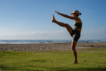 beautiful young girl goes in for sports on the seashore does different exercises